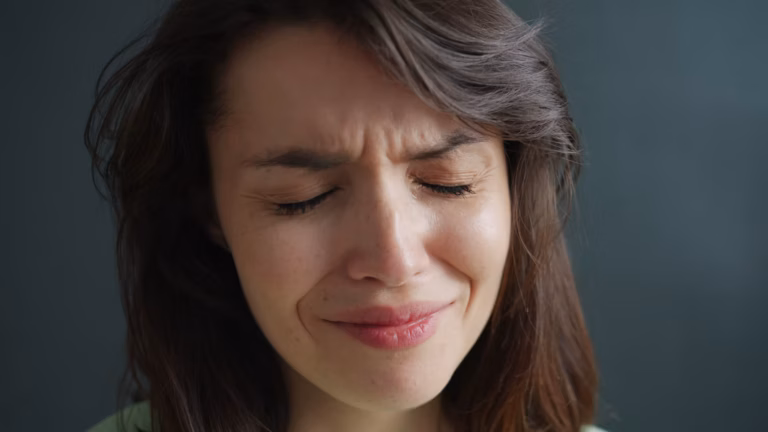 Shot of a young woman looking sad while holding a teddy bear
